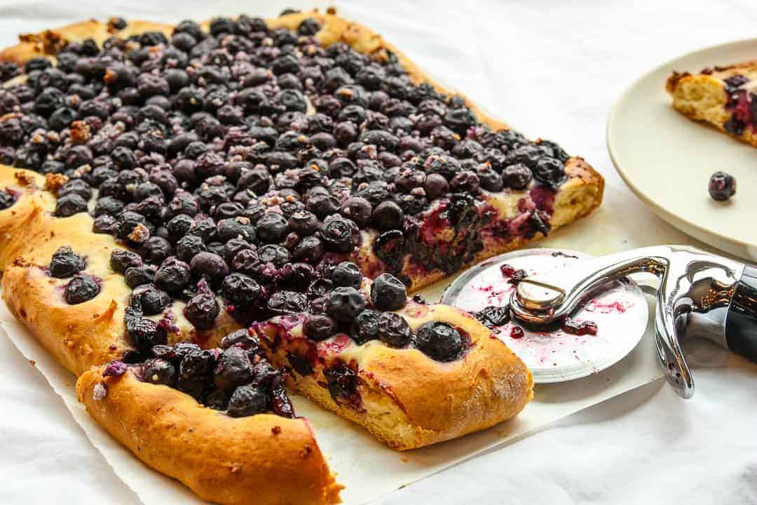 A blueberry pie being slices