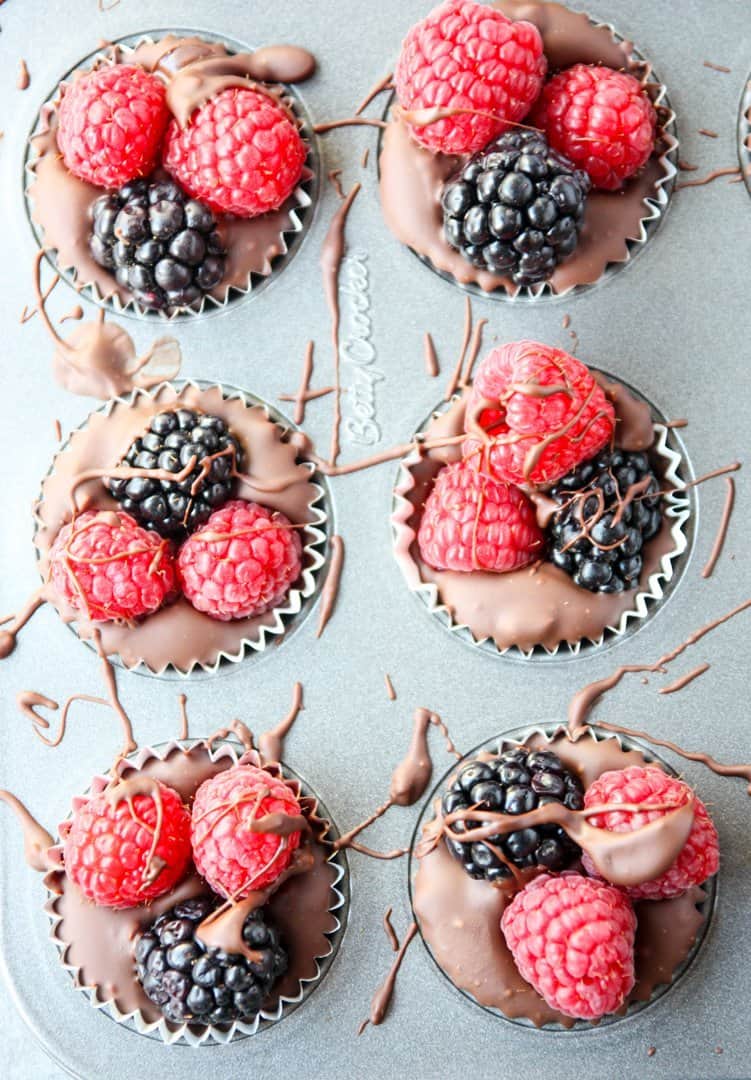 Chocolate cups with raspberries and blackberries in a mini muffin pan